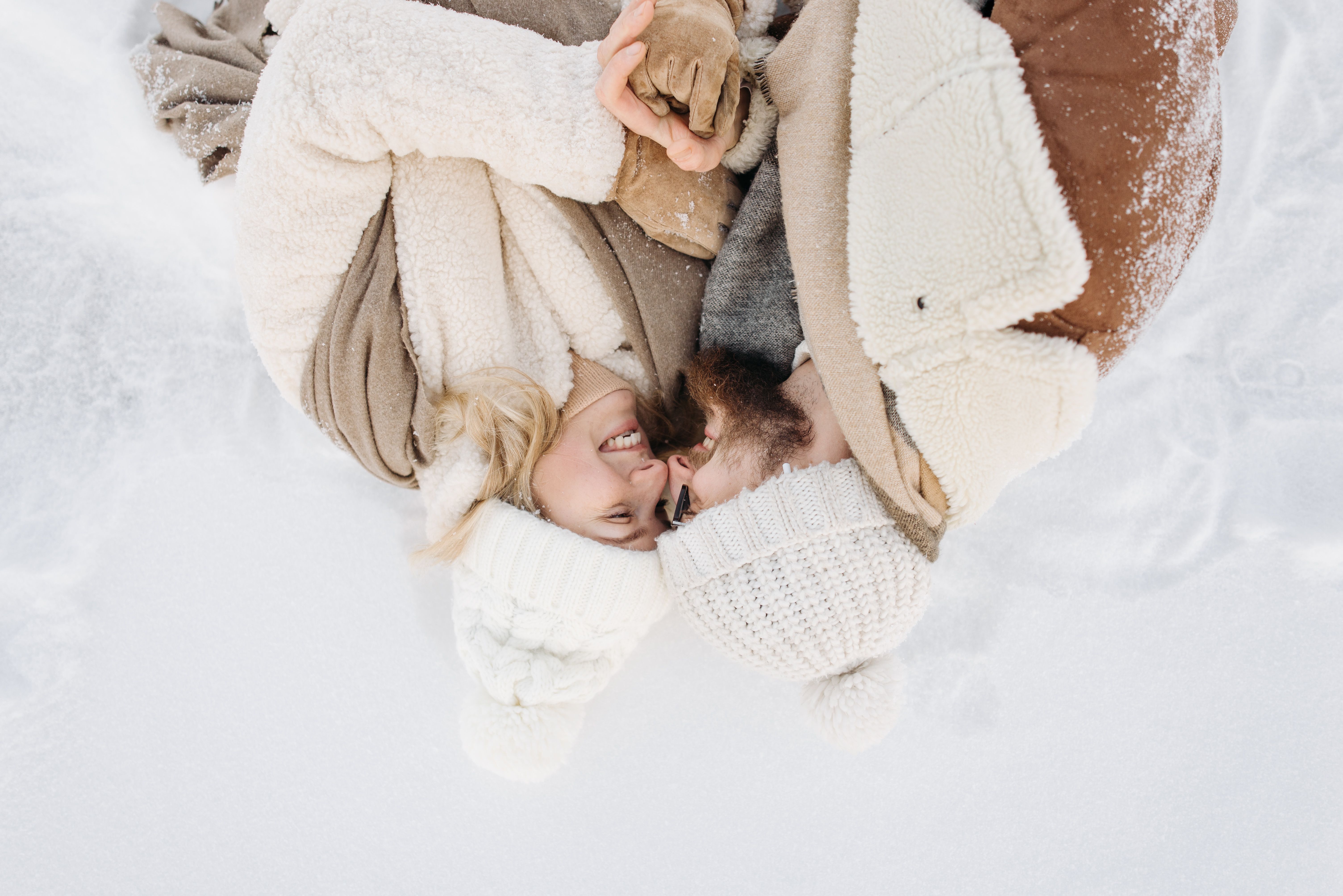 A Couple in Winter Clothes Lying on Snow · Free Stock Photo