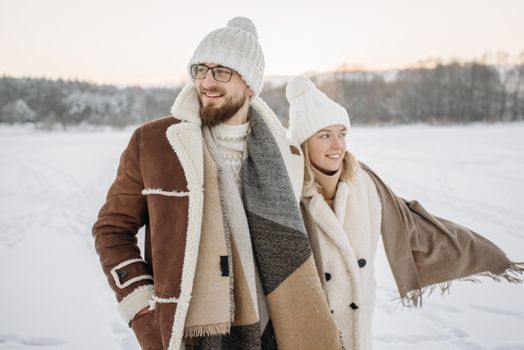 Warmly dressed couple enjoying a snowy day outdoors on a frozen lake.