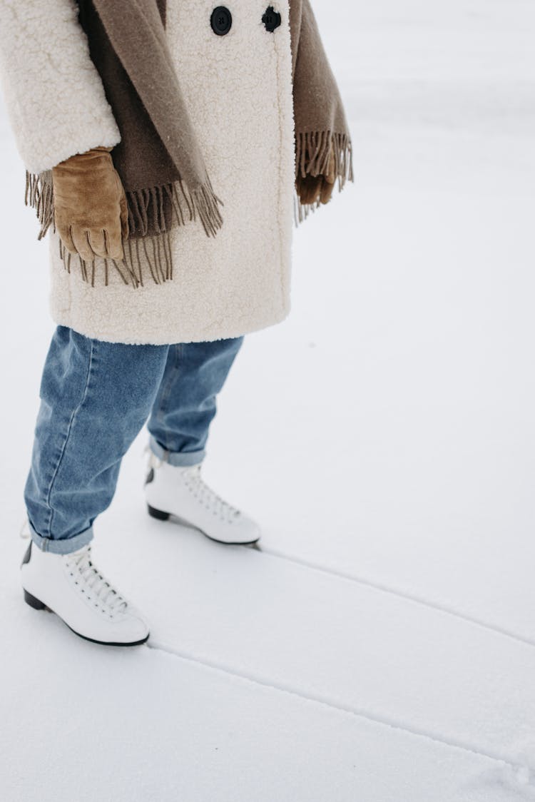 Person In Blue Denim Jeans Wearing Ice Skates