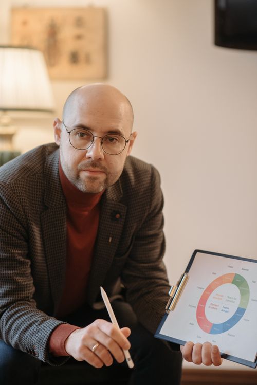Free A professional man in an office setting presenting a circle graph on a clipboard. Stock Photo