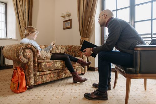 Free Therapist and client in a session indoors, discussing while seated in a cozy room. Stock Photo