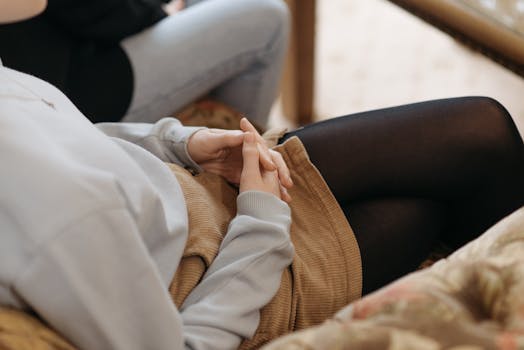 Close-up of a teenager's hands clasped in a counseling session, symbolizing contemplation.