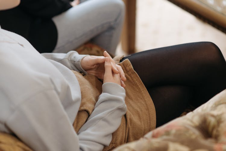 Girl Sitting With Clasped Hands On The Lap