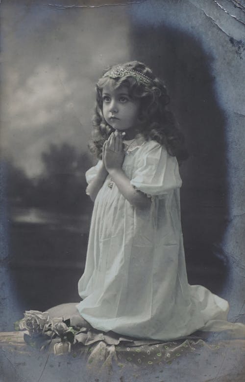 Little Girl in White Dress With Headress Praying
