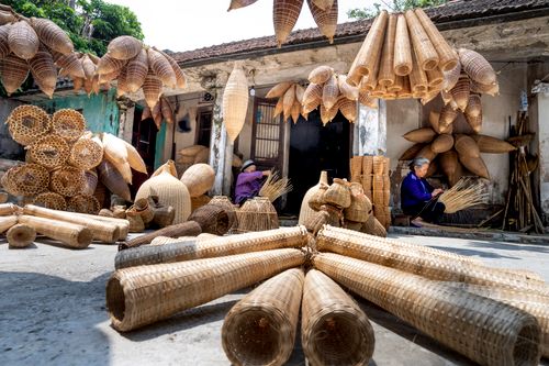 Free Wooden traditional Vietnamese fish traps placed on ground and hanging near shabby old house Stock Photo