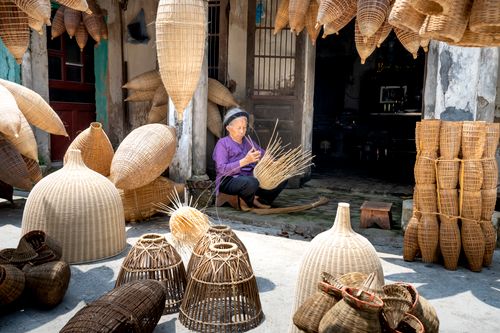 Free Full body of elderly ethnic female among timber wicker fish traps in sunny yard in daylight Stock Photo