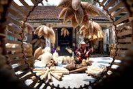 Vietnamese senior people in yard among bamboo traditional fish traps