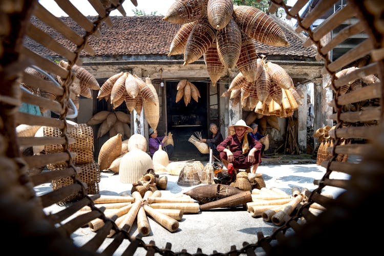 Vietnamese Senior People In Yard Among Bamboo Traditional Fish Traps