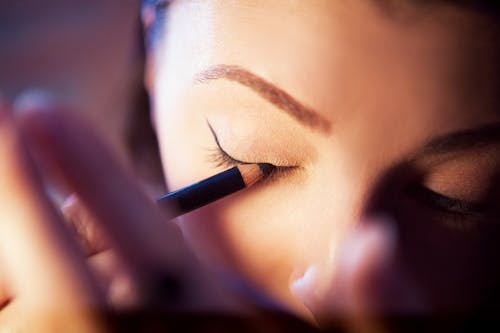 A Woman Applying an Eyeliner