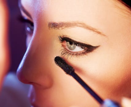 Detailed close-up of a woman applying mascara to her eyelashes, highlighting eye makeup.