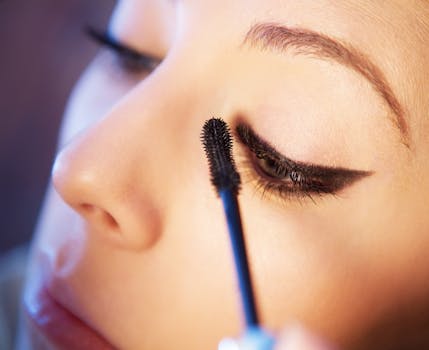 Detailed close-up of a woman applying mascara to enhance her eye makeup look.