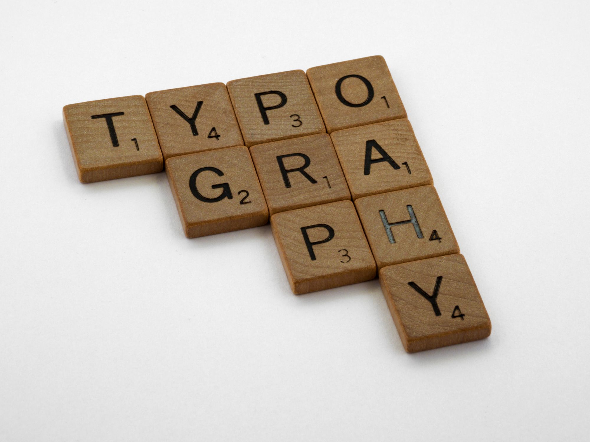 Wooden Scrabble tiles spelling Typography