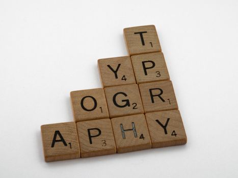 Scrabble tiles arranged to spell 'Typography' on a white background for minimalist design.