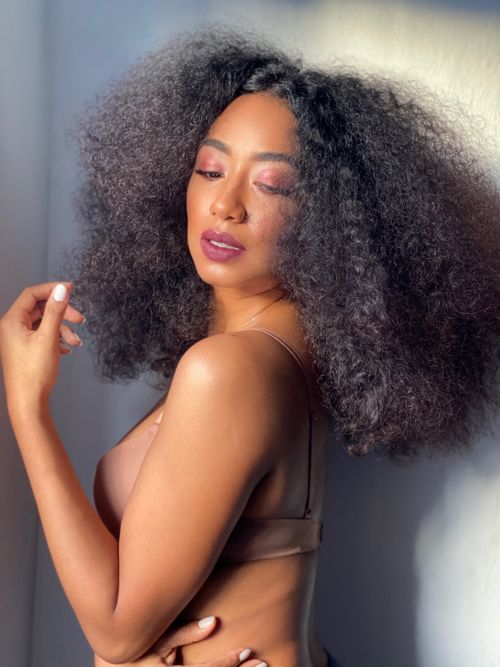 Free Elegant portrait of an adult woman with voluminous curly hair in natural lighting. Stock Photo