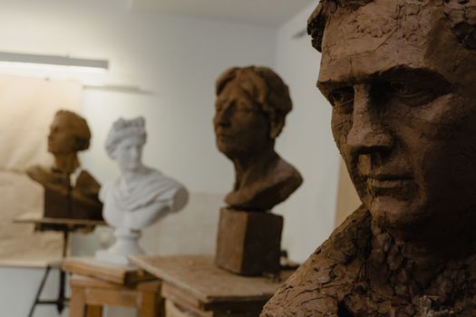 Close-up of clay sculptures in an art studio workshop environment.