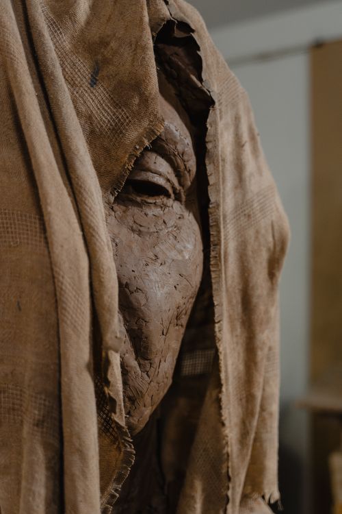 Free A close-up of a clay sculpture draped in textured cloth, showcasing artistic craftsmanship. Stock Photo
