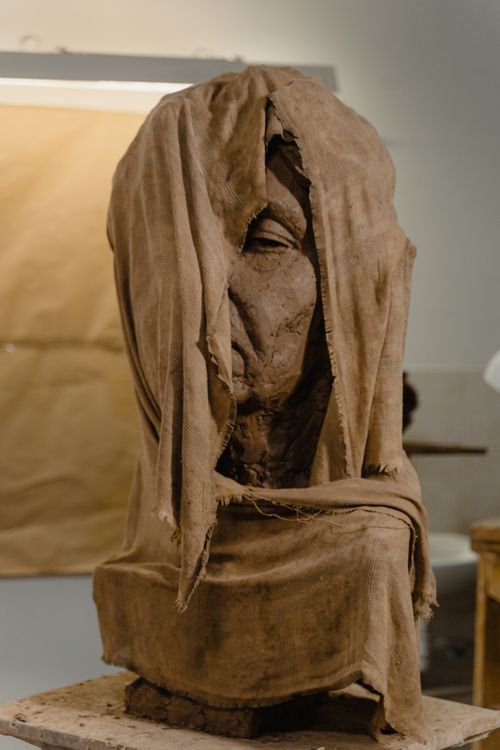 Free Intriguing clay sculpture wrapped in cloth, showcasing artistic techniques in a studio setting. Stock Photo