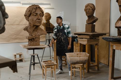 Free Talented artist working on detailed clay sculptures in an art studio setting. Stock Photo