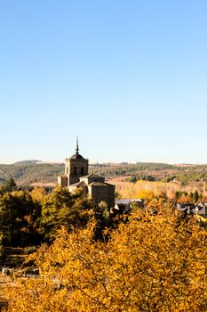 Picturesque view of a church amid autumn foliage and a calm rural backdrop.