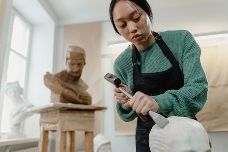 A Woman Holding A Chisel And Hammer