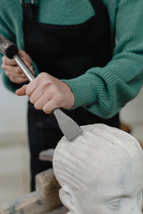 A Person Using a Hammer and a Chisel on a Sculpture · Free Stock Photo