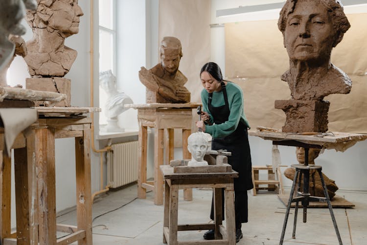 A Sculptor Using A Hammer And A Chisel