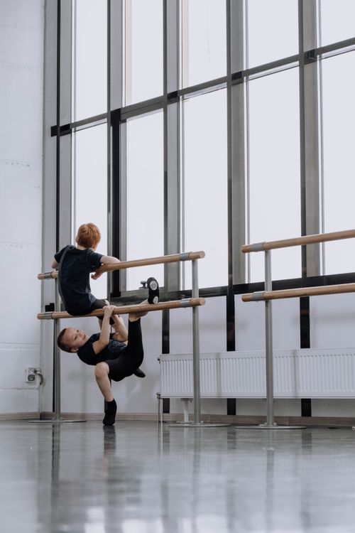 Free Boys having fun practicing dance moves in a bright ballet studio. Stock Photo