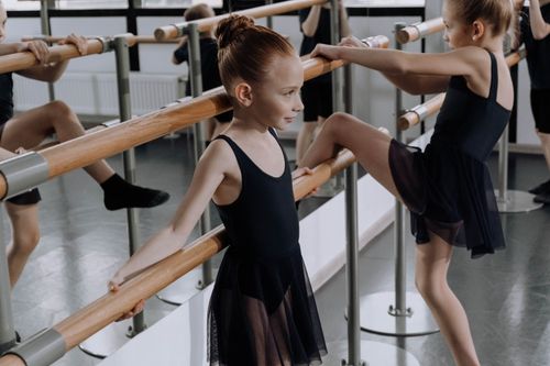 Free Young ballerinas in a studio practicing ballet techniques at the barre. Stock Photo