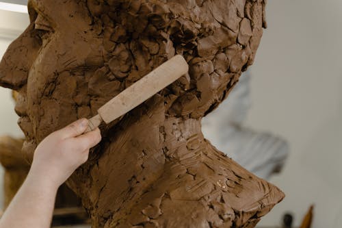 Person Making a Clay Statue