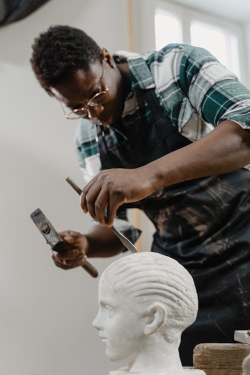 A Man Using a Hammer and a Chisel