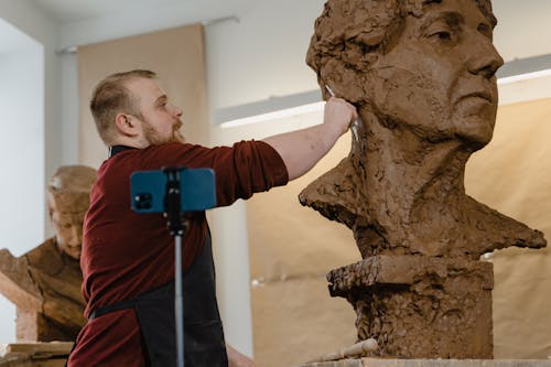 Man Working On A Clay Head Sculpture