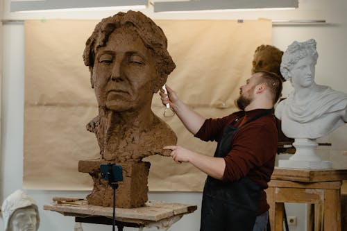 Free Man Working On A Clay Head Sculpture Stock Photo