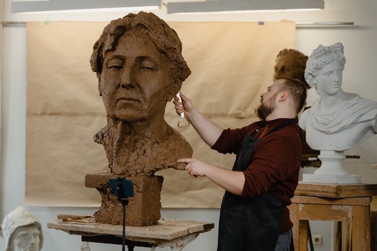 Man Working On A Clay Head Sculpture