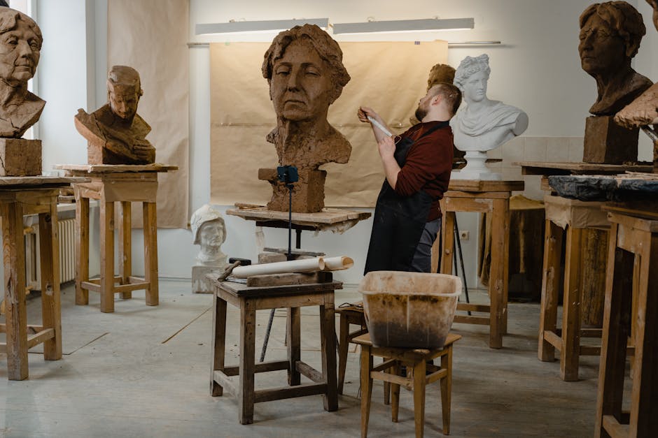 Man in Blue Sweater Sitting on Brown Wooden Seat