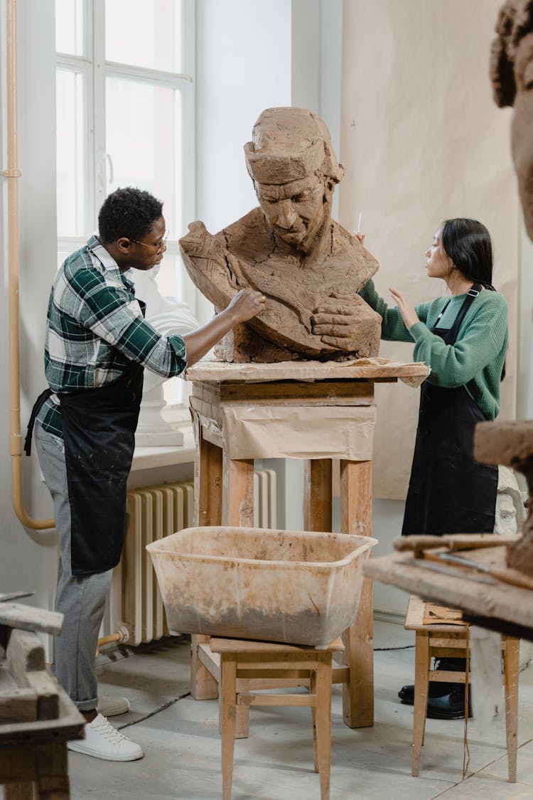 Sculptors Shaping A Clay Statue