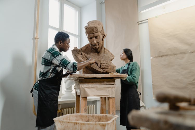 Artists Sculpting Clay Into A Statue