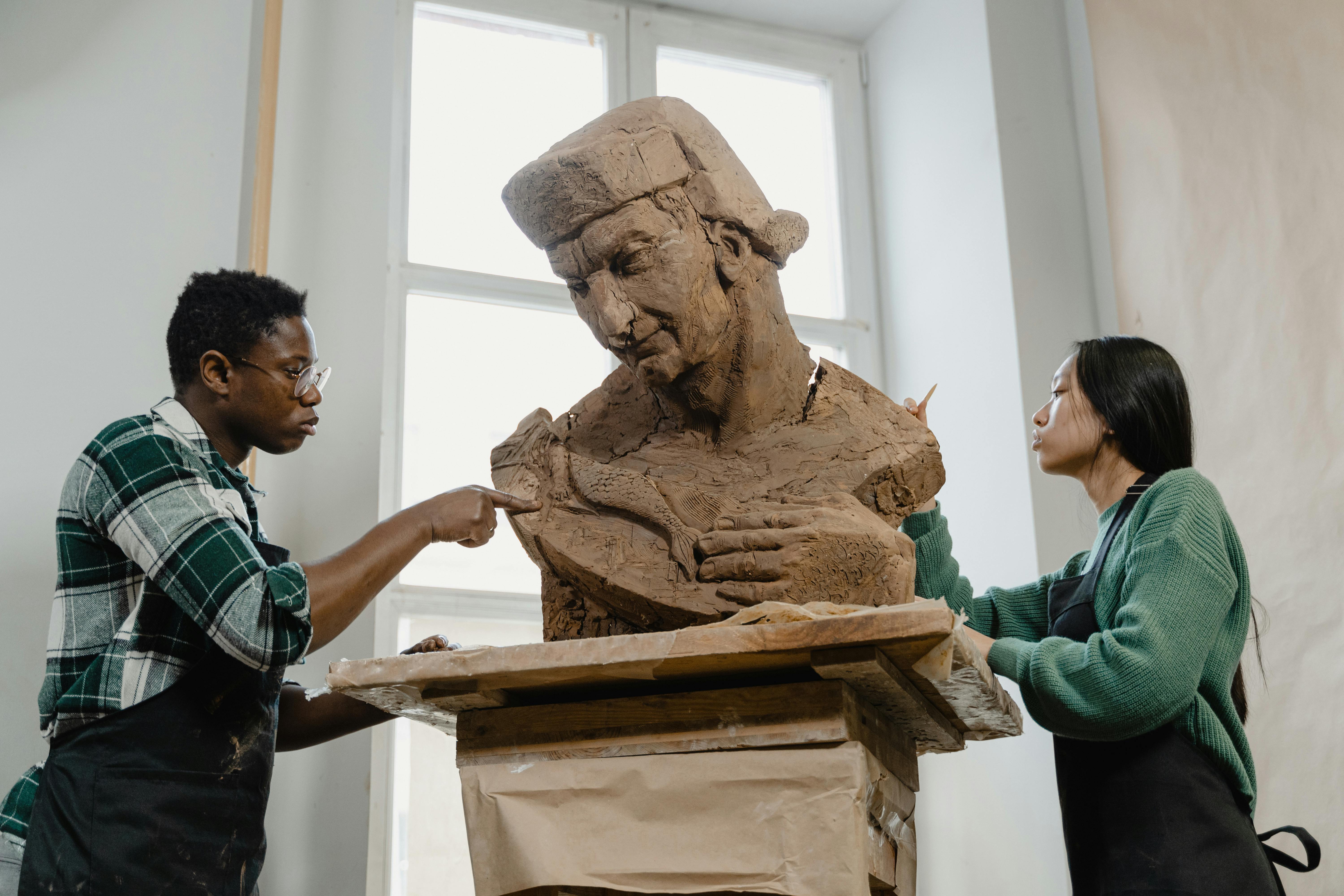 A Man and a Woman Sculpting Clay Statue · Free Stock Photo