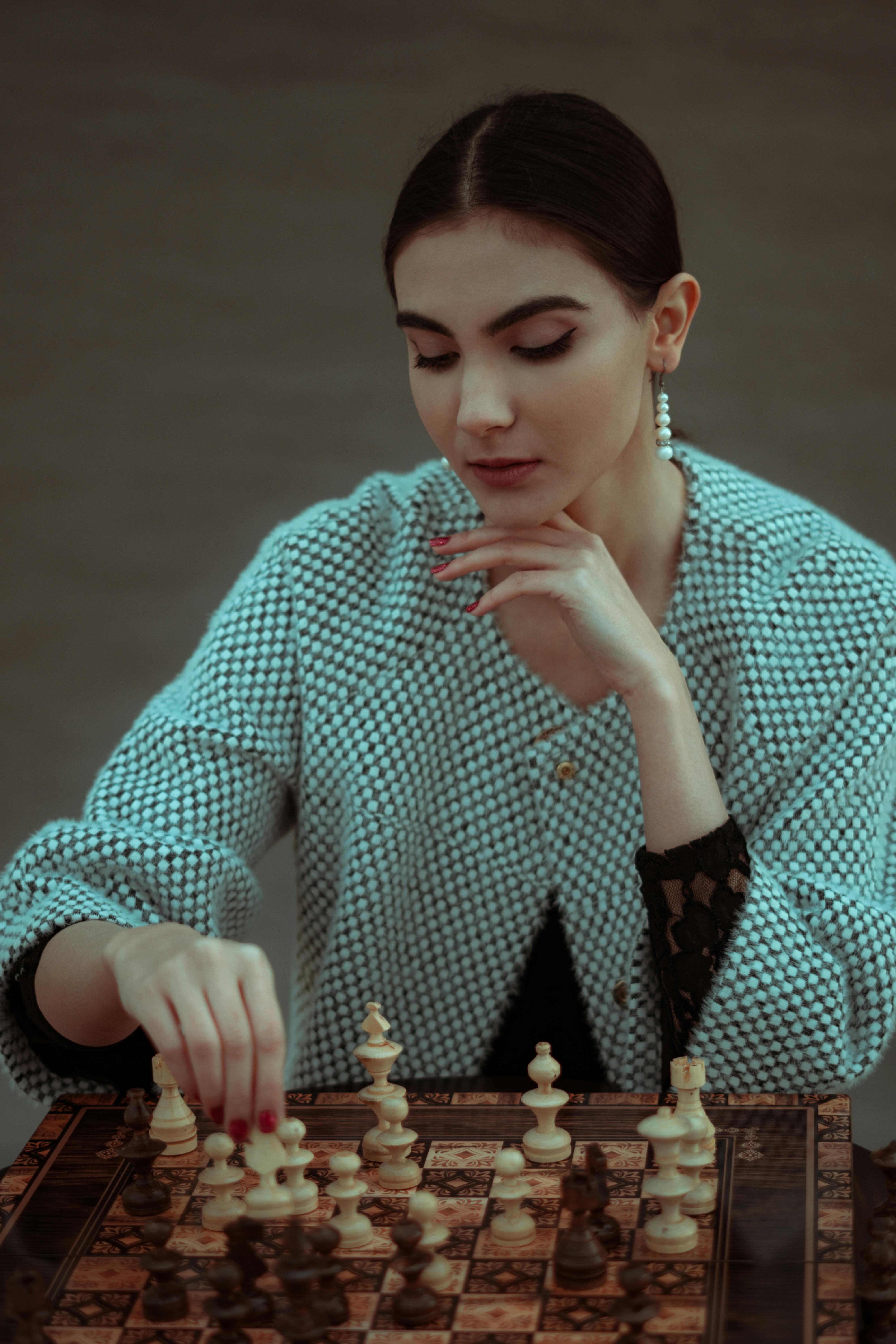 Woman playing chess thinking of next move Stock Photo - Alamy