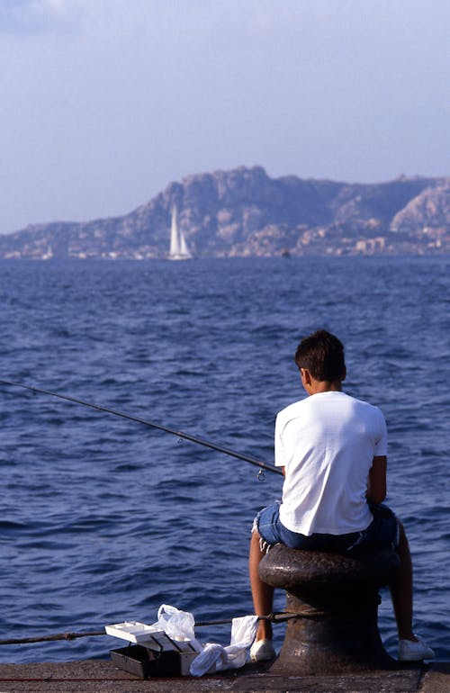Free Back View of a Man Sitting While Fishing Stock Photo