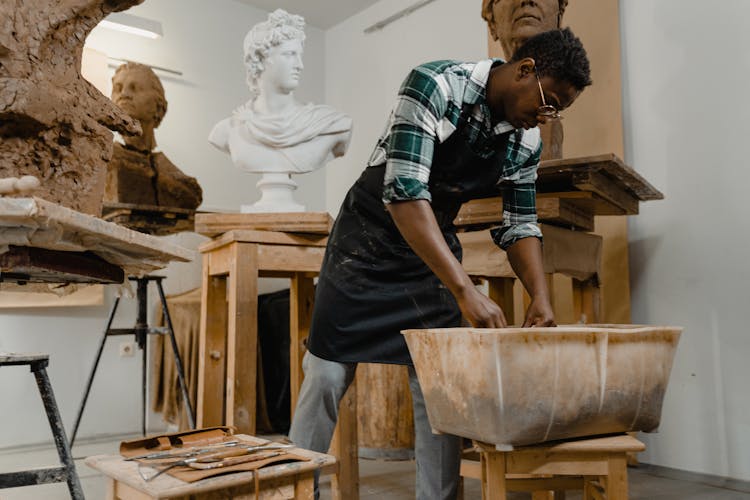 A Man Near Sculptures In An Art Studio