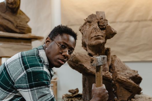Artist working on a clay sculpture in an art studio, showcasing creativity and craftsmanship.
