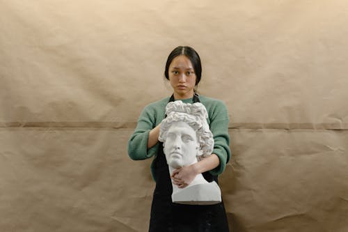 Free Woman Holding a Head Statue Stock Photo