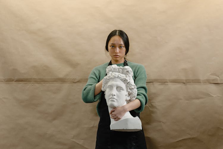 Woman Holding A Head Statue