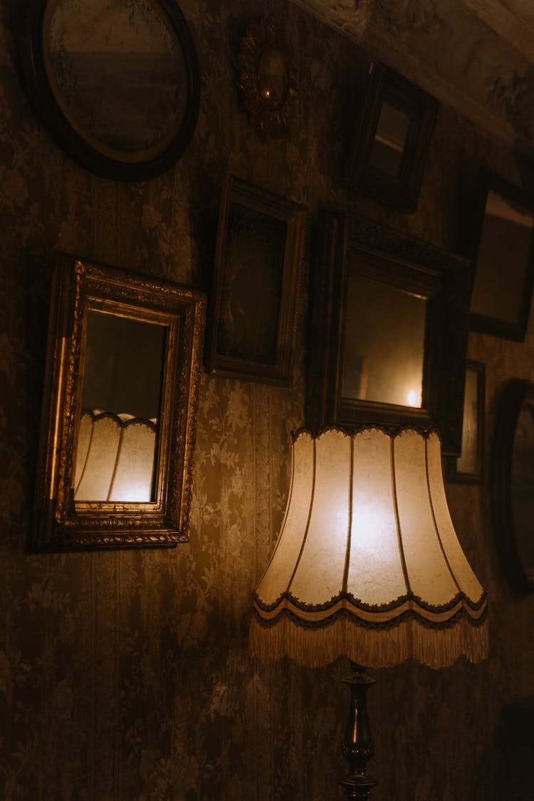 Brown Wooden Framed Wall Mirrors Near A Table Lamp