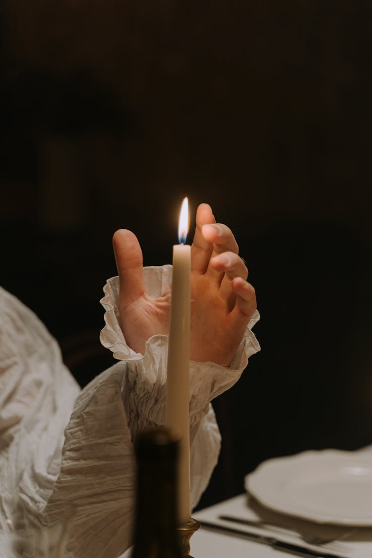 A Hand Near A Burning Candle 