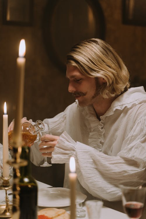 A Man in Medieval Pouring Wine in a Glass