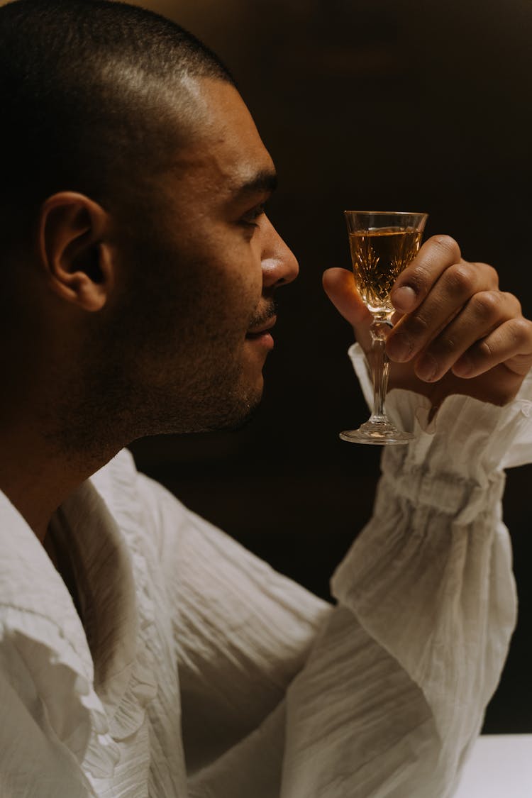 A Man In White Ruffle Long Sleeve Shirt Drinking Alcohol