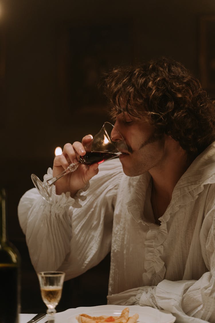 Man In Empire Style Shirt Drinking Red Wine