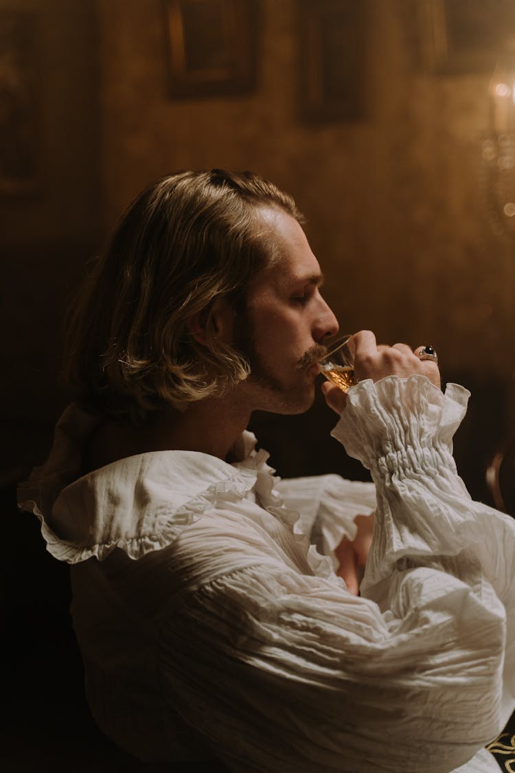 Man In Empire Style Costume Drinking Alcohol