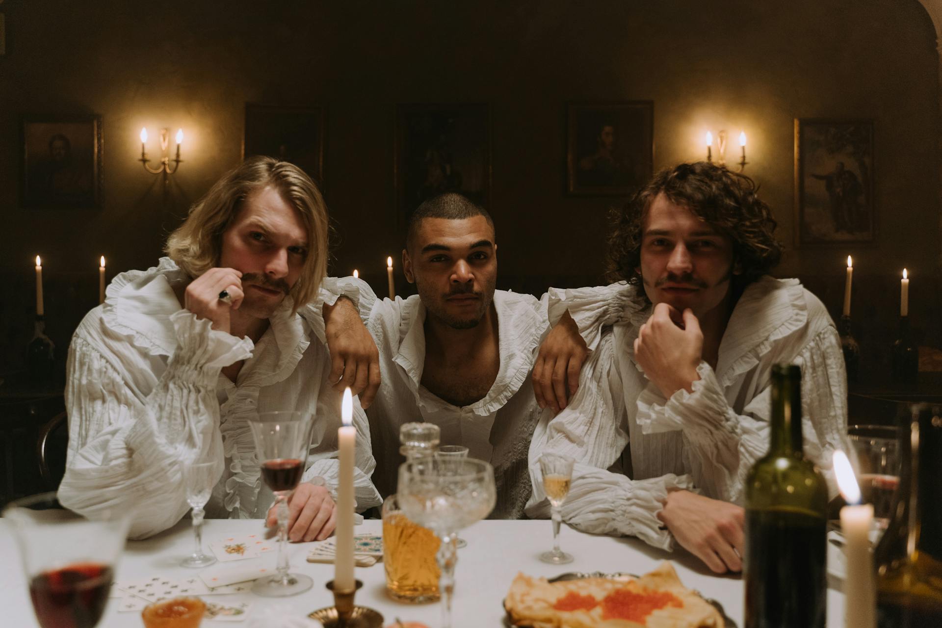 A Group of Medieval Looking Men Sitting at the Table with Wine